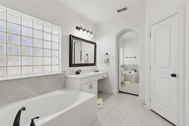 full bathroom featuring visible vents, baseboards, a bathing tub, tile patterned flooring, and vanity