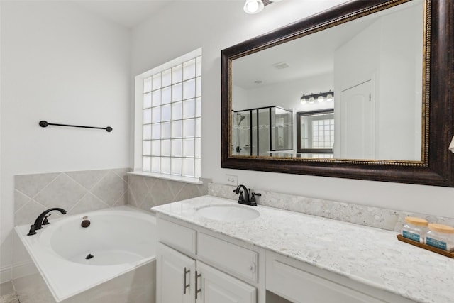 full bath with a stall shower, a bath, and vanity