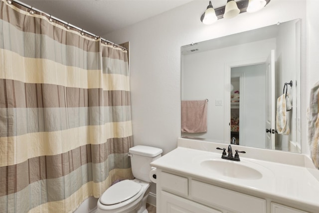 full bathroom featuring a shower with shower curtain, vanity, and toilet