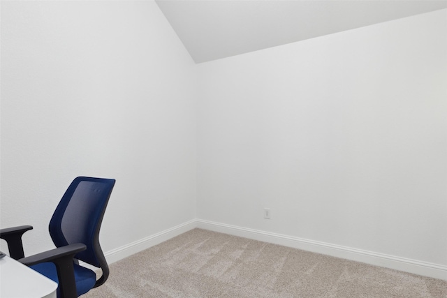 office area featuring light colored carpet, vaulted ceiling, and baseboards