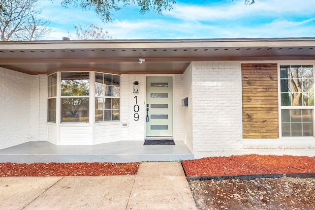 doorway to property with brick siding