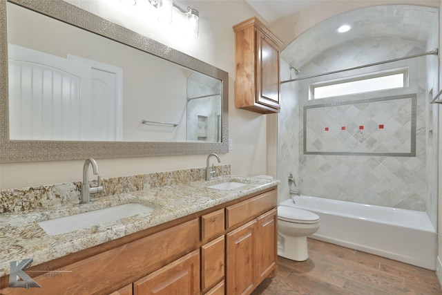 bathroom with toilet, shower / bathing tub combination, a sink, and wood finished floors