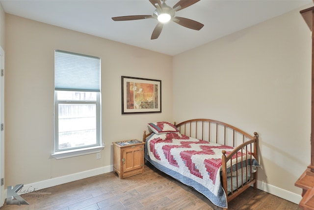 bedroom with light wood-type flooring, baseboards, and a ceiling fan