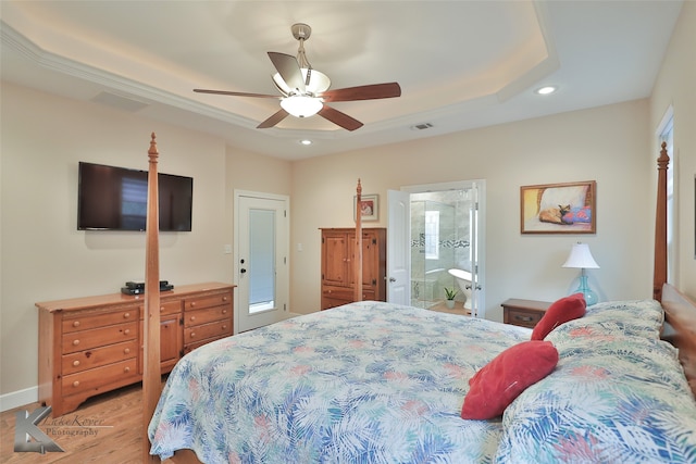 bedroom featuring recessed lighting, ceiling fan, light wood-style flooring, and a tray ceiling