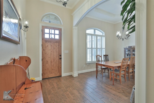 foyer with ornamental molding, wood finished floors, and a healthy amount of sunlight