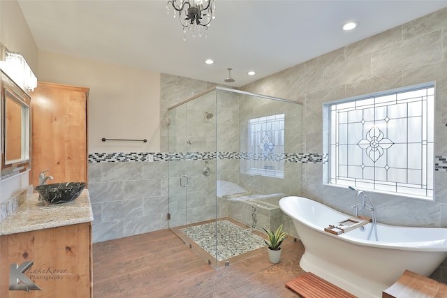 full bath with a freestanding bath, a stall shower, tile walls, and recessed lighting