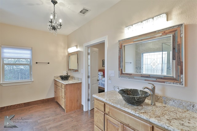 bathroom with visible vents, vanity, ensuite bath, wood finished floors, and baseboards