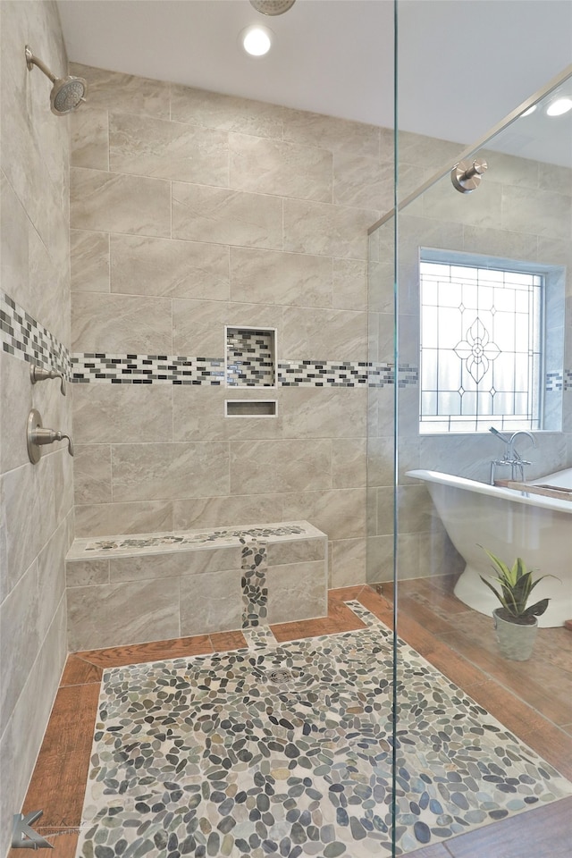 full bathroom featuring a soaking tub and tiled shower