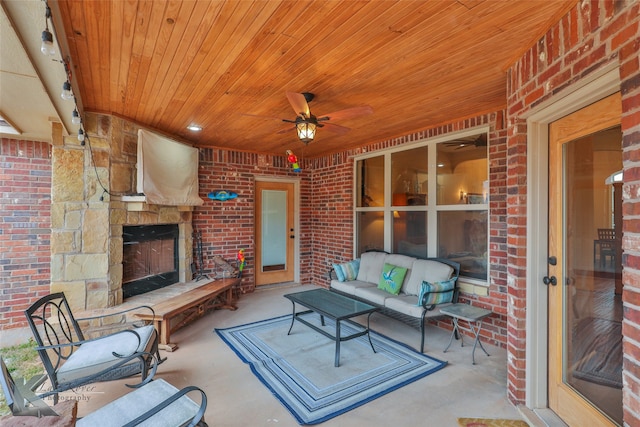 view of patio / terrace featuring an outdoor living space with a fireplace and a ceiling fan