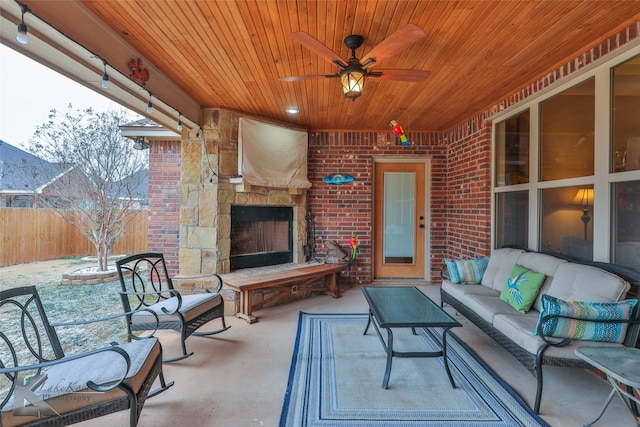 view of patio / terrace with fence, an outdoor living space with a fireplace, and ceiling fan