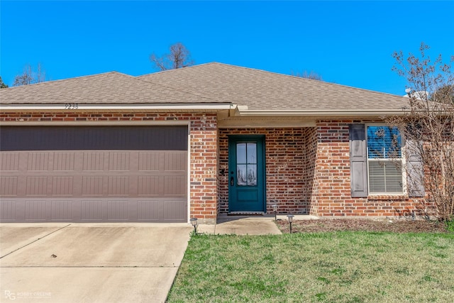 ranch-style house featuring driveway, roof with shingles, an attached garage, a front lawn, and brick siding