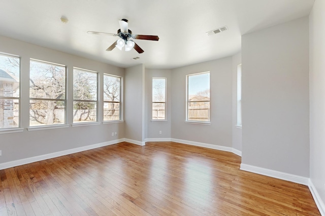 spare room with visible vents, ceiling fan, light wood-style flooring, and baseboards