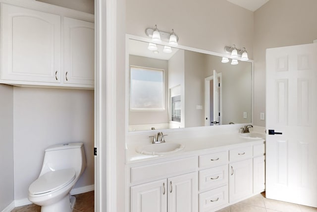 bathroom with toilet, tile patterned flooring, baseboards, and a sink