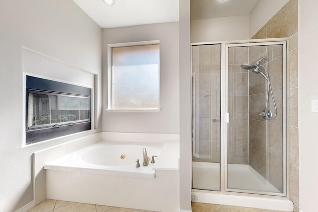 bathroom featuring a shower stall, a bath, and tile patterned floors