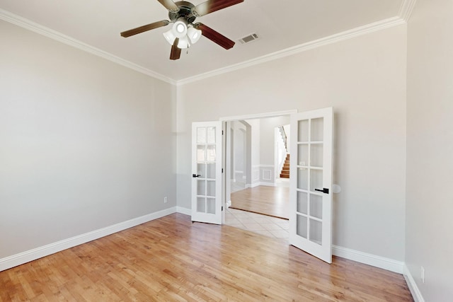 spare room featuring french doors, visible vents, crown molding, and light wood finished floors