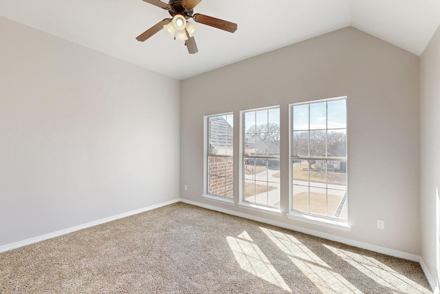 spare room featuring lofted ceiling, carpet, baseboards, and ceiling fan