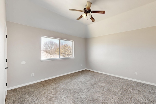 empty room featuring vaulted ceiling, carpet, a ceiling fan, and baseboards