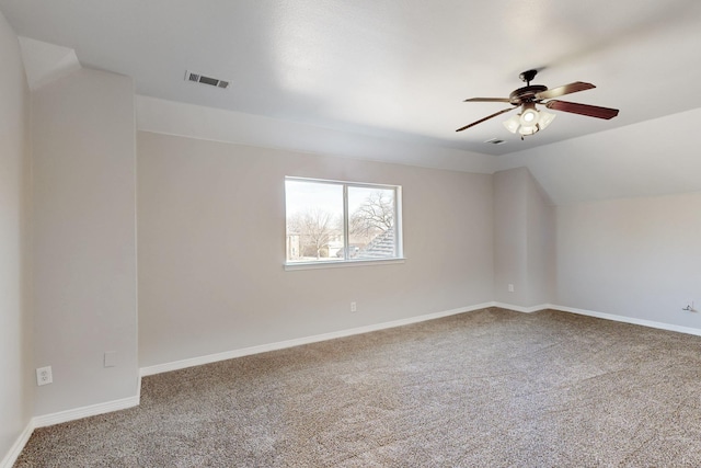 interior space featuring lofted ceiling, baseboards, visible vents, and carpet flooring