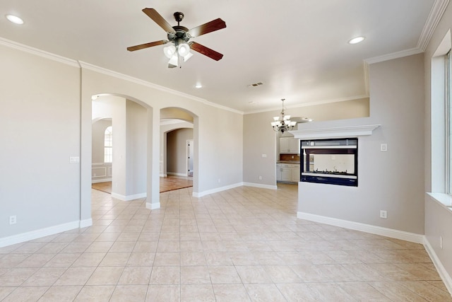 unfurnished living room featuring arched walkways, ceiling fan with notable chandelier, visible vents, baseboards, and crown molding