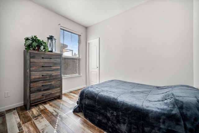 bedroom featuring baseboards and wood finished floors