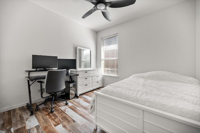 bedroom with ceiling fan, baseboards, and wood finished floors