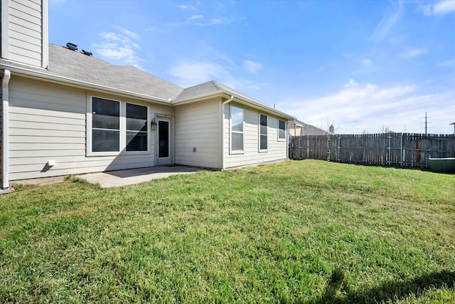 back of property featuring a yard, fence, and a patio