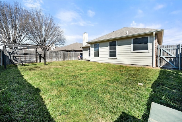 view of yard with a fenced backyard and a gate