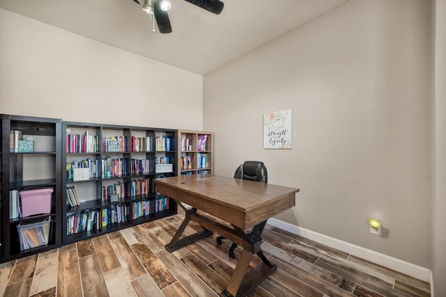 home office with a ceiling fan, baseboards, and wood finished floors