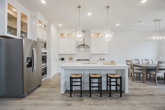 kitchen with stainless steel appliances, light wood-style floors, light countertops, and a sink