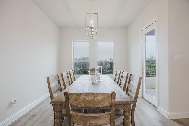 dining area with light wood-type flooring, a wealth of natural light, and baseboards