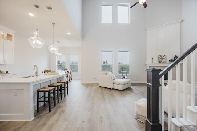 living room with light wood-style floors, a healthy amount of sunlight, a fireplace, and stairs