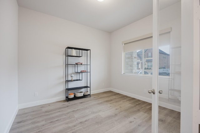 empty room featuring light wood-type flooring and baseboards