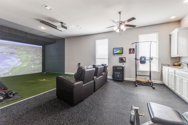 home theater featuring golf simulator, recessed lighting, visible vents, a sink, and baseboards