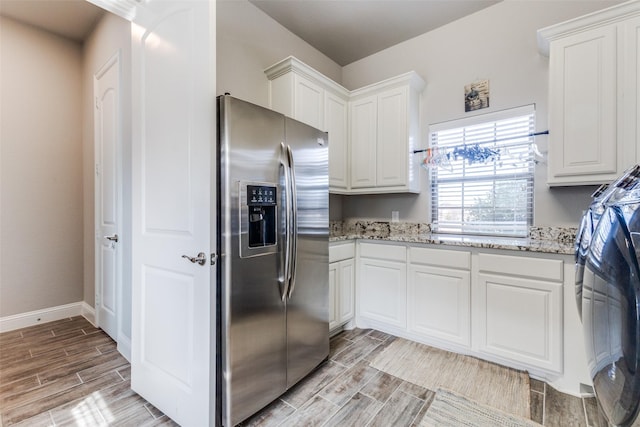 kitchen with stainless steel fridge, wood tiled floor, and white cabinetry