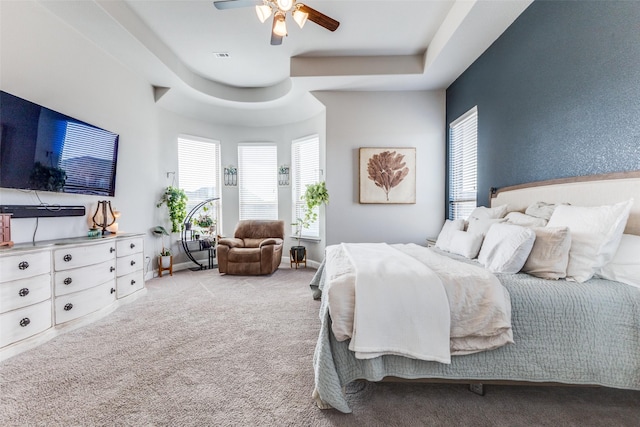 bedroom with carpet, baseboards, visible vents, and a tray ceiling