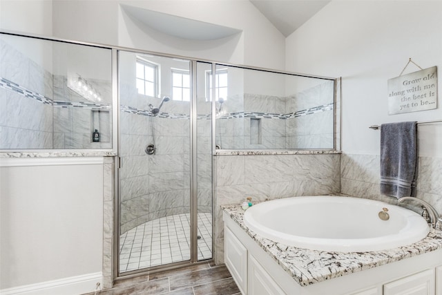 bathroom featuring lofted ceiling, a shower stall, and a bath