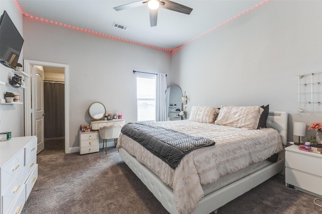 bedroom featuring a ceiling fan, visible vents, and dark carpet