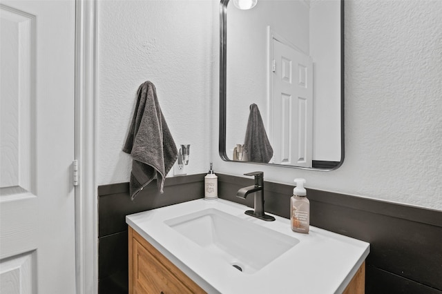 bathroom featuring a textured wall and vanity