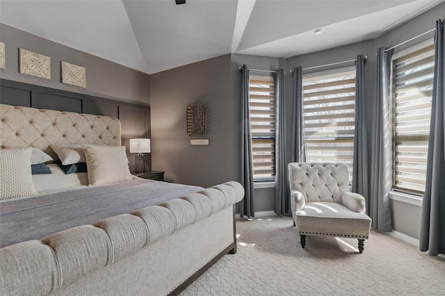 bedroom with light carpet, vaulted ceiling, and baseboards