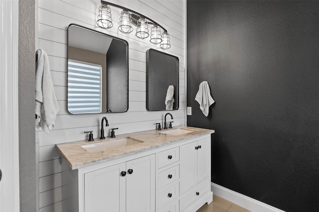 full bath with tile patterned floors, a sink, baseboards, and double vanity