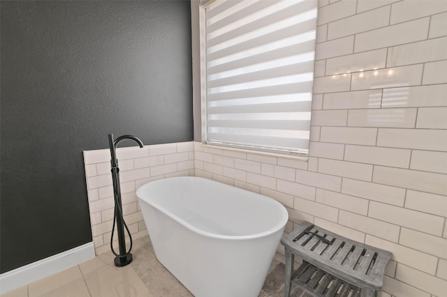 full bathroom with a textured wall, a soaking tub, tile walls, and tile patterned floors