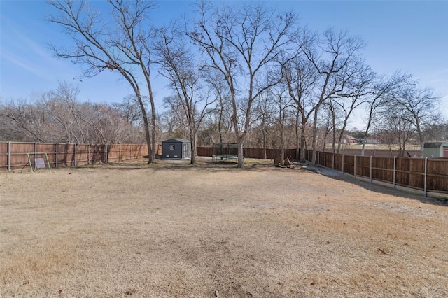 view of yard featuring a storage shed, an outdoor structure, and a fenced backyard