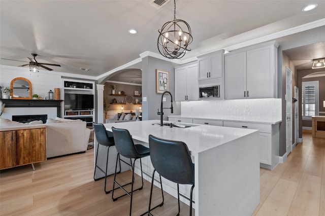 kitchen featuring arched walkways, light countertops, a fireplace, and a sink