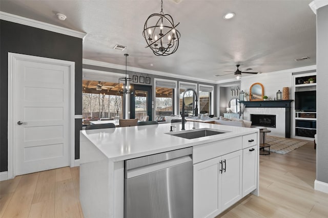 kitchen featuring ceiling fan, a fireplace, a sink, visible vents, and stainless steel dishwasher