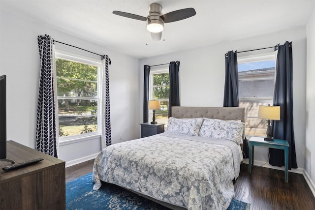 bedroom with ceiling fan, wood finished floors, and baseboards