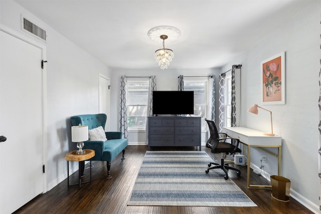 office space with an inviting chandelier, baseboards, visible vents, and wood finished floors