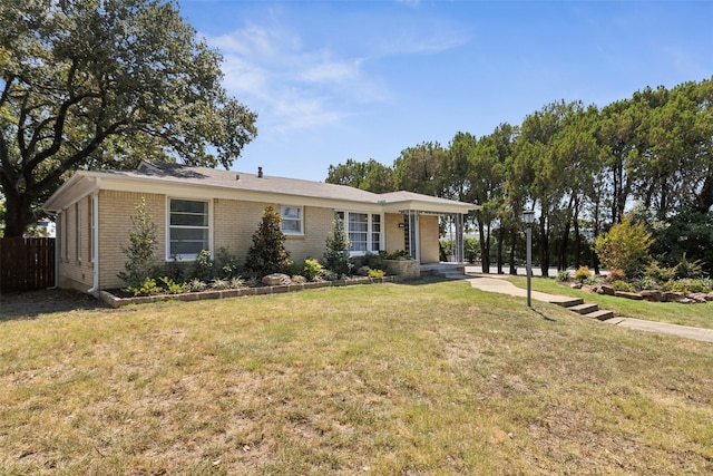 single story home featuring a front yard, brick siding, and fence