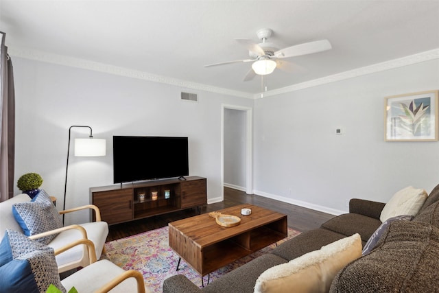 living room featuring baseboards, visible vents, a ceiling fan, wood finished floors, and crown molding