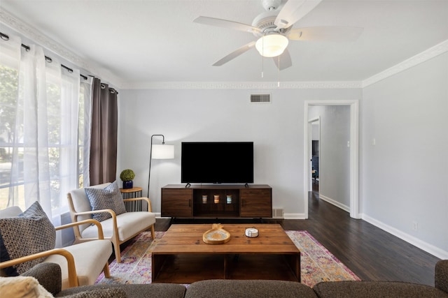 living room with baseboards, visible vents, a ceiling fan, wood finished floors, and crown molding