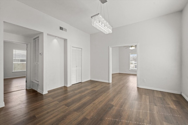 unfurnished room featuring dark wood-style flooring, visible vents, ceiling fan, and baseboards